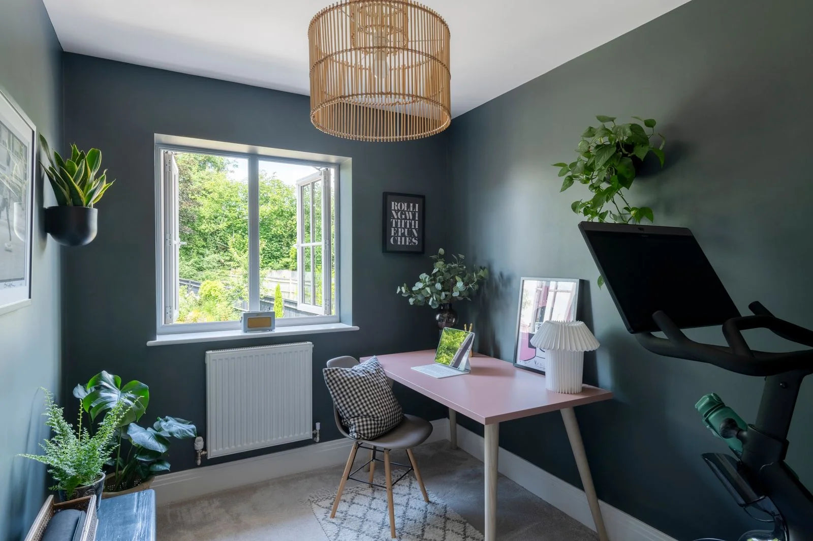 Modern dark moody home office and Peloton studio with view of the garden