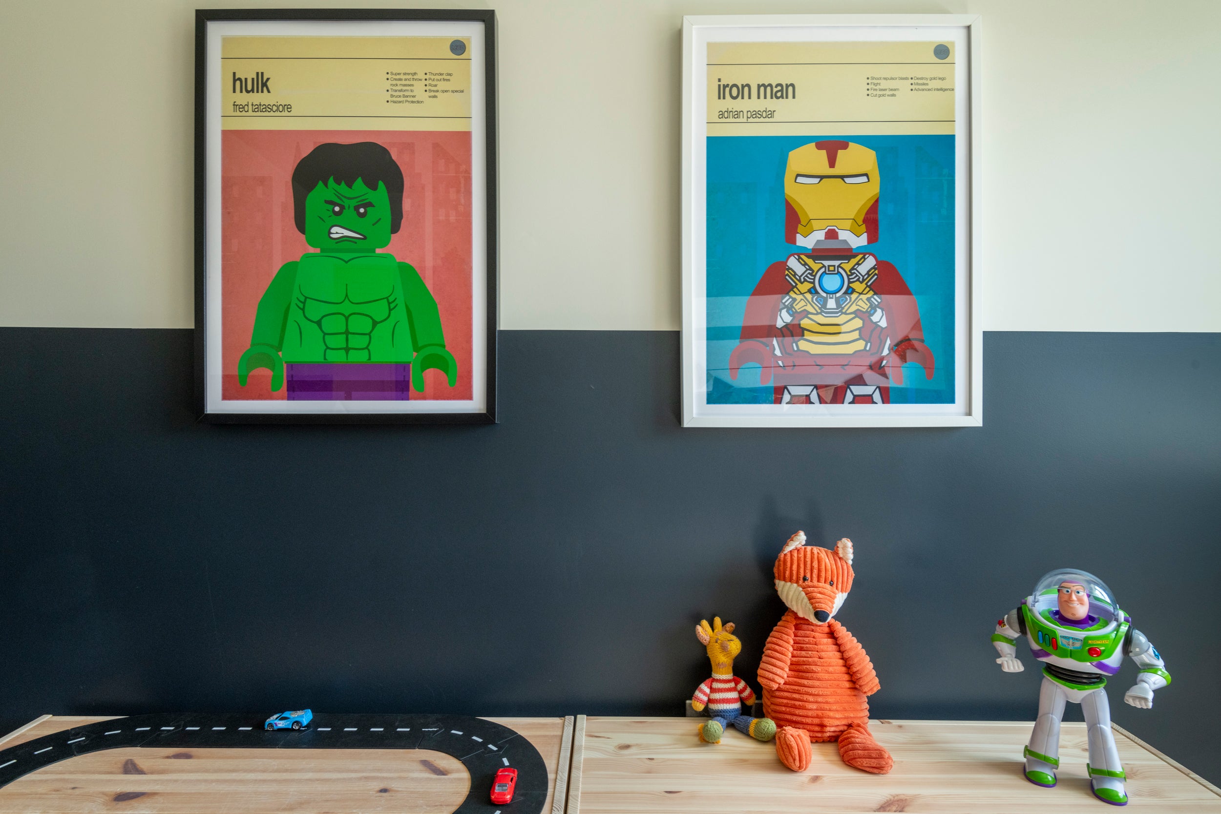 Picture of play area with two art prints that are lego super hero’s. The walls are two toned off white and Farrow and Ball Railings. 