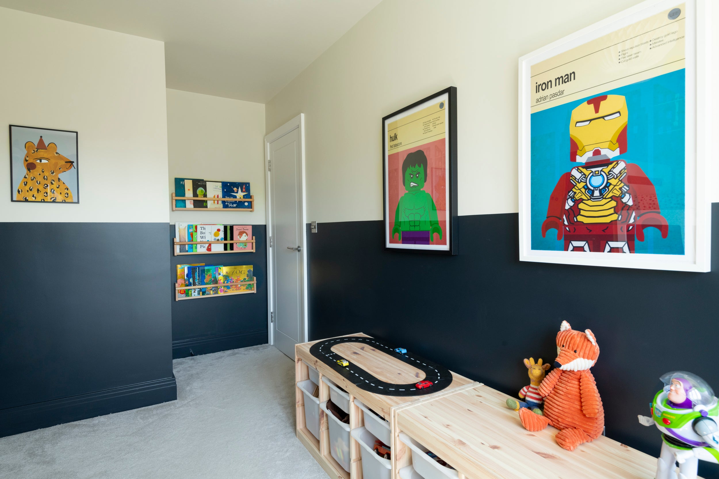 Boy’s bedroom with two toned walls using Farrow and Ball Old School White and Railings. Bright stylish art work on the wall, toy storage on the floor and book shelves on the walls.